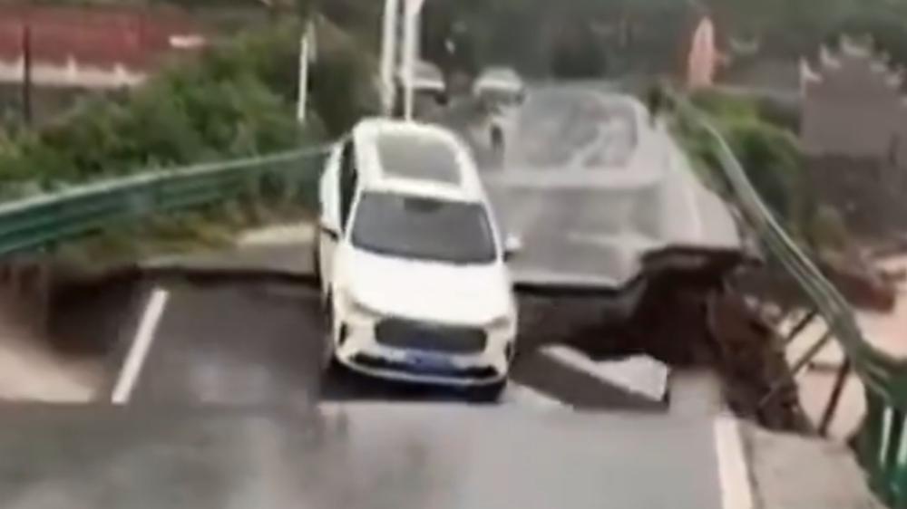 Carro cai de ponte e é levado por enchente na China