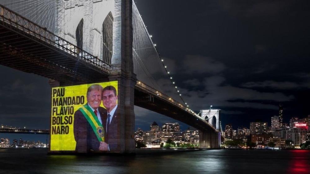 Protesto em Nova York usa IA para mostrar Flávio entregando faixa a Trump